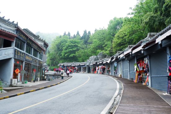 There are local eateries and souvenir shops on both sides of the road in Nan Yan