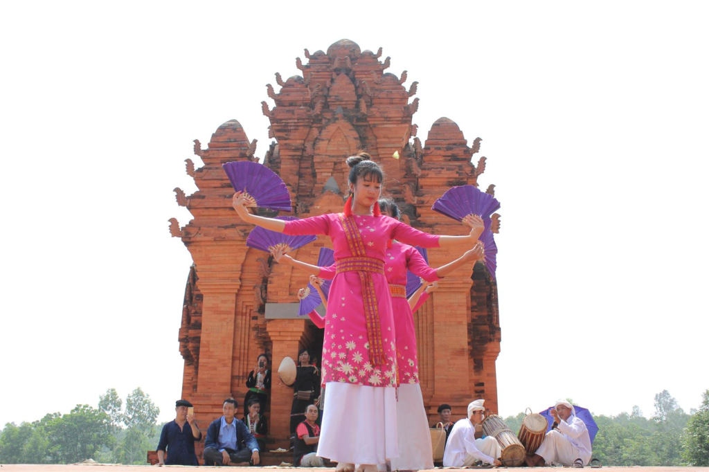 A traditional performance of Cham people in front of their Cham tower at the Vietnam National Village for Ethnic Culture and Tourism